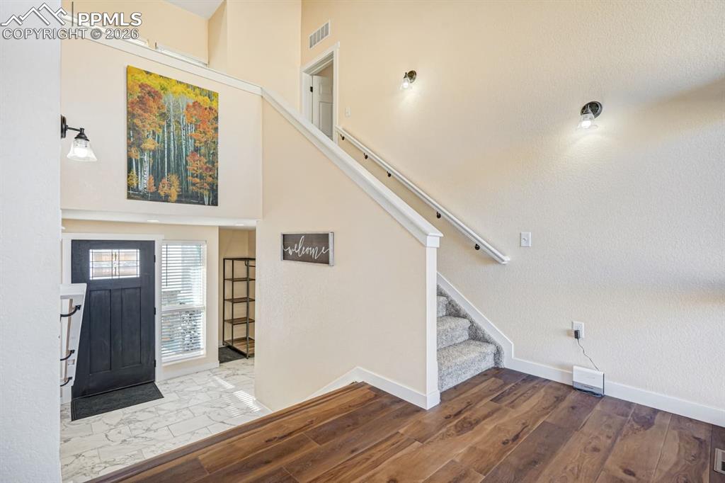 10108 Rolling Ridge Road Colorado Springs, CO 80925 - Photo 12 of 32 a view of a hallway with wooden floor and staircase