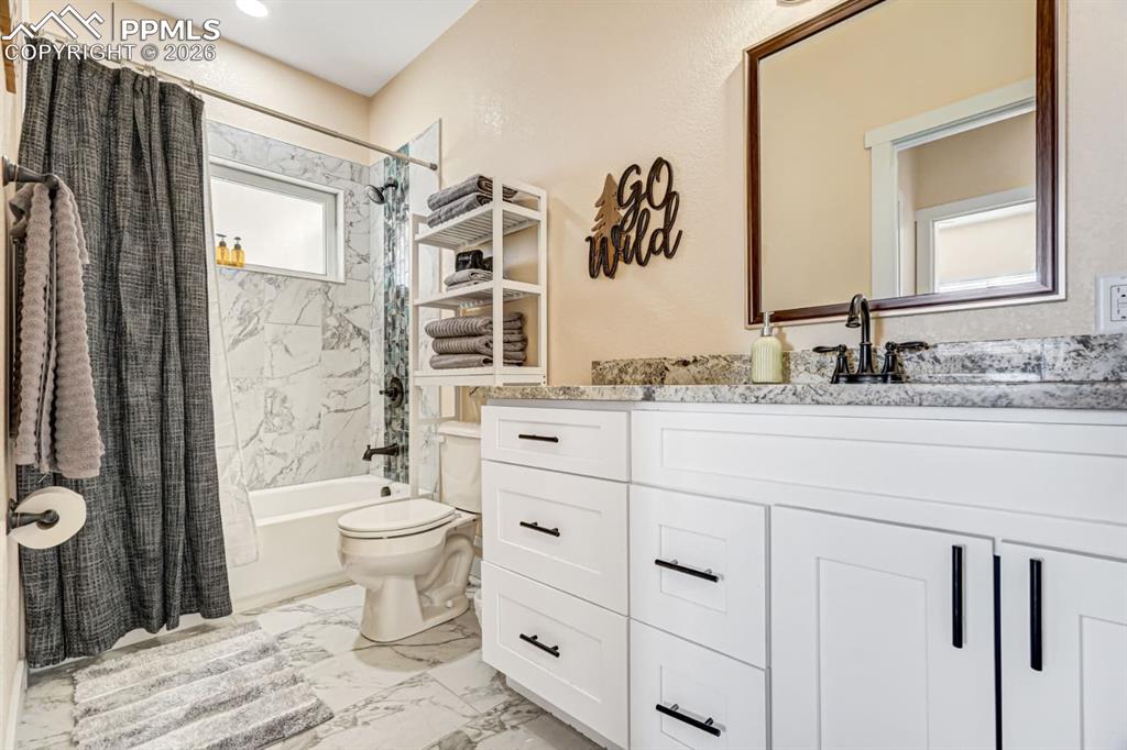 10108 Rolling Ridge Road Colorado Springs, CO 80925 - Photo 15 of 32 a bathroom with a sink toilet and shower