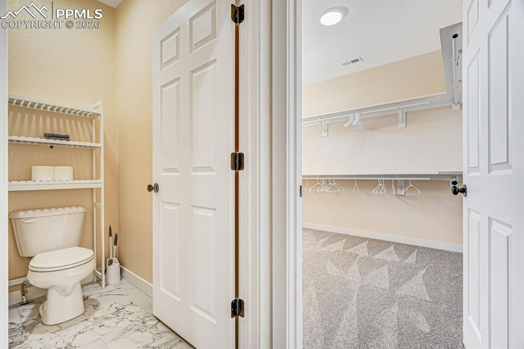 10108 Rolling Ridge Road Colorado Springs, CO 80925 - Photo 18 of 32 a bathroom with a toilet and a shower