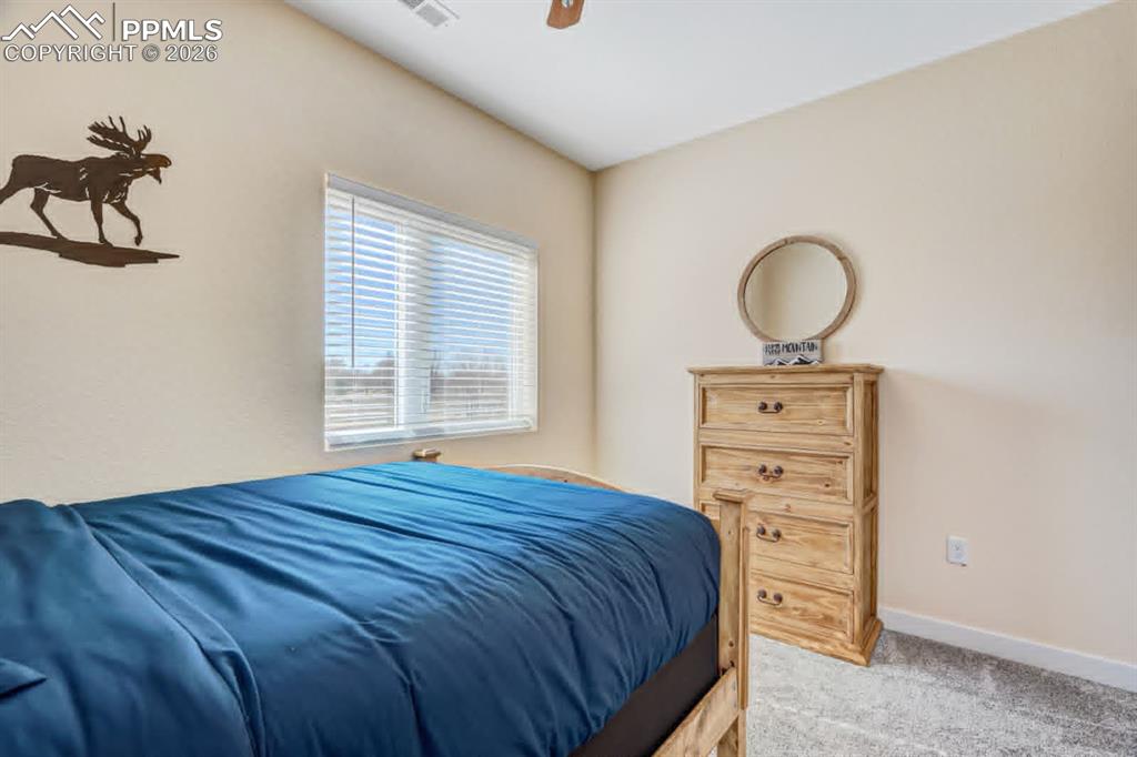 10108 Rolling Ridge Road Colorado Springs, CO 80925 - Photo 21 of 32 a bedroom with a bed and a dresser