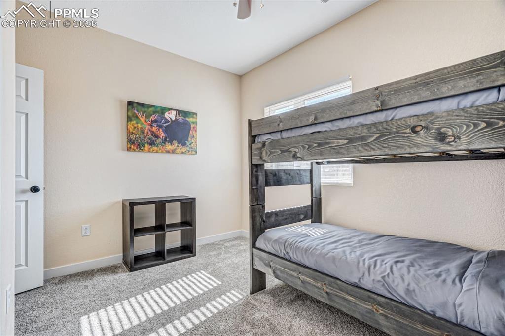 10108 Rolling Ridge Road Colorado Springs, CO 80925 - Photo 22 of 32 a bedroom with a bed and painting on the wall