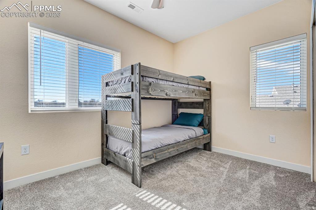 10108 Rolling Ridge Road Colorado Springs, CO 80925 - Photo 23 of 32 a bedroom with a bed and a window