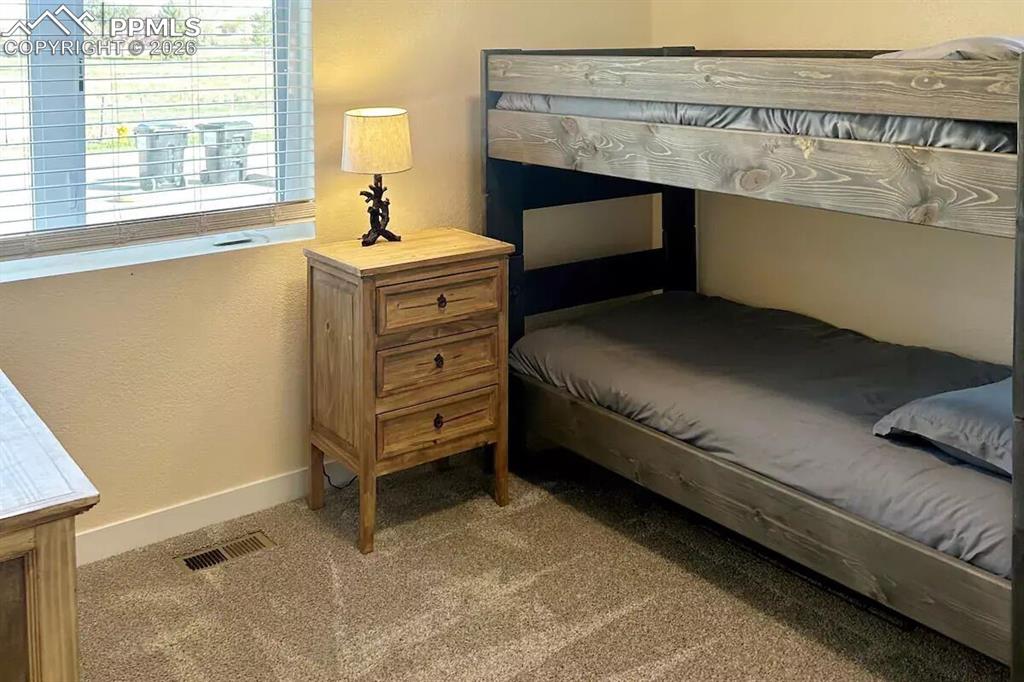 10108 Rolling Ridge Road Colorado Springs, CO 80925 - Photo 26 of 32 a bedroom with a bed and a window