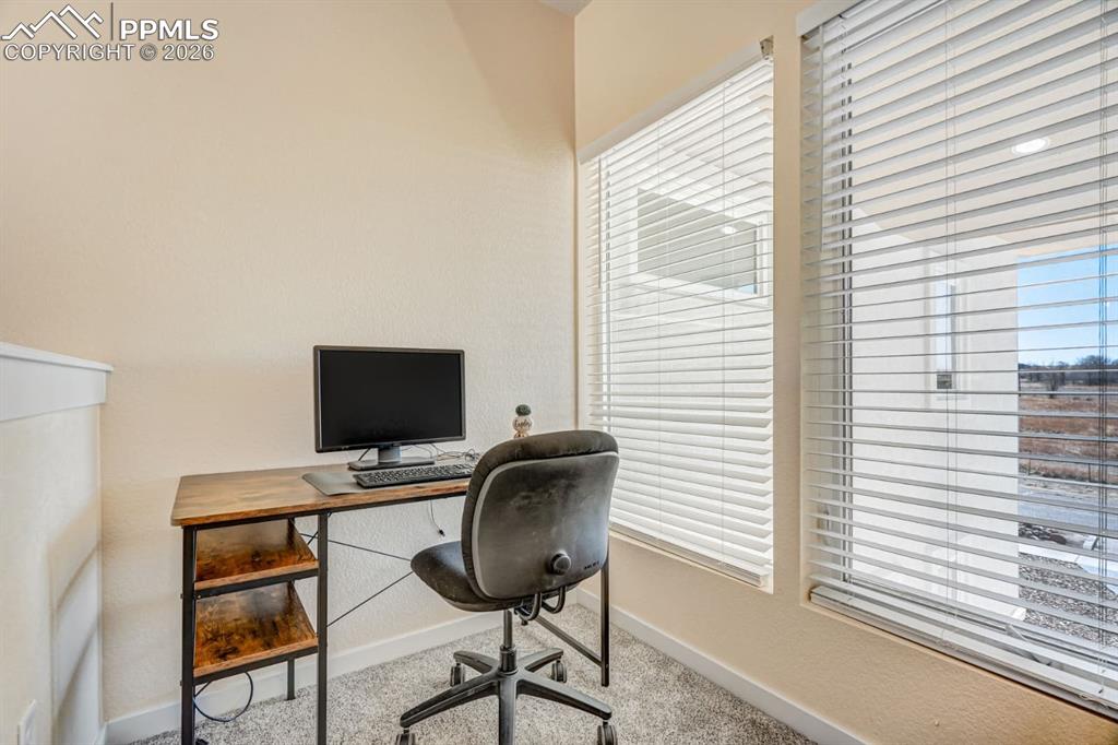 10108 Rolling Ridge Road Colorado Springs, CO 80925 - Photo 28 of 32 a view of a workspace with furniture and a window