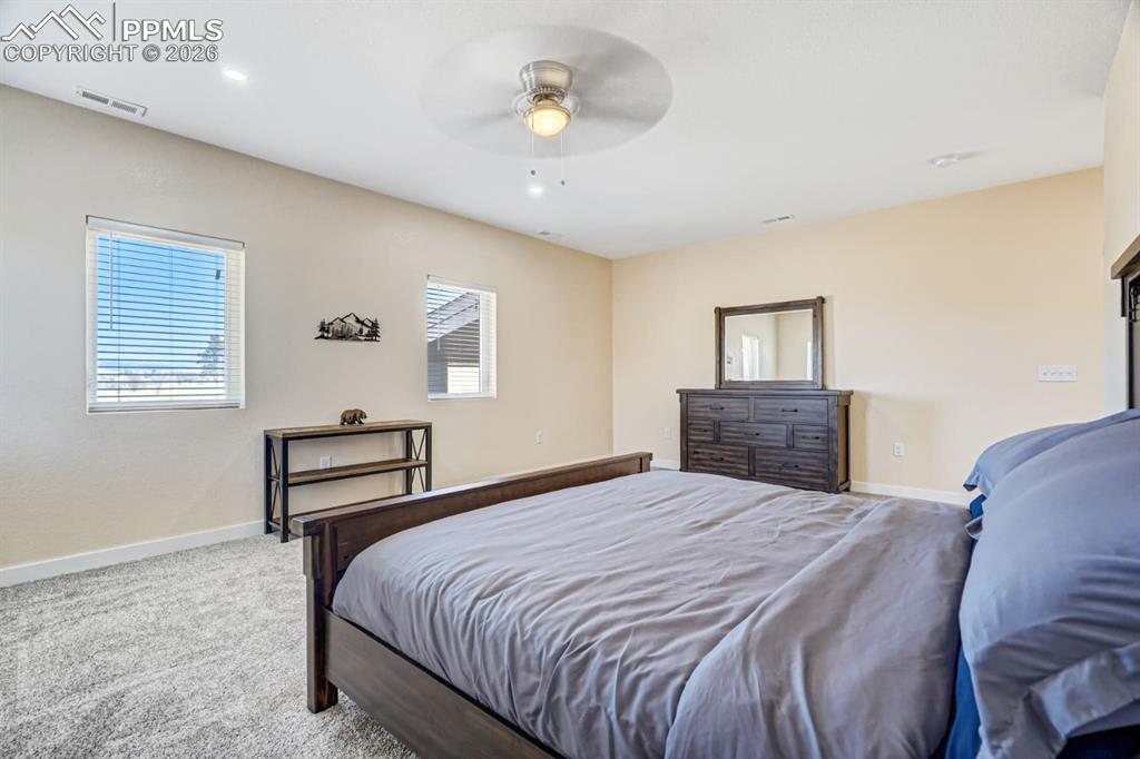10108 Rolling Ridge Road Colorado Springs, CO 80925 - Photo 29 of 32 a bedroom with a bed and a chandelier