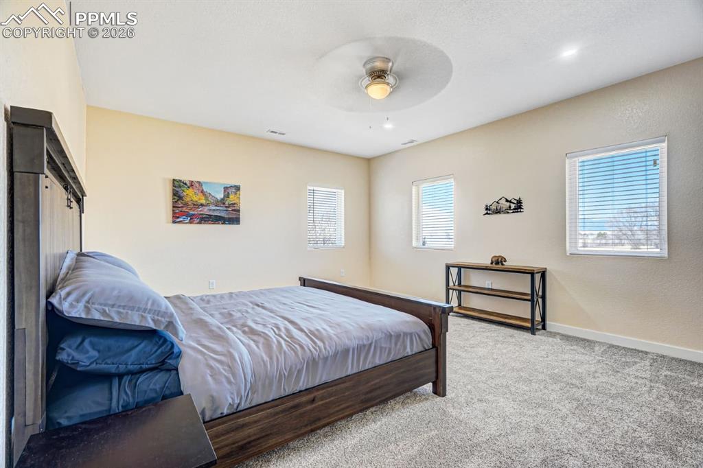 10108 Rolling Ridge Road Colorado Springs, CO 80925 - Photo 30 of 32 a bedroom with a bed and a potted plant