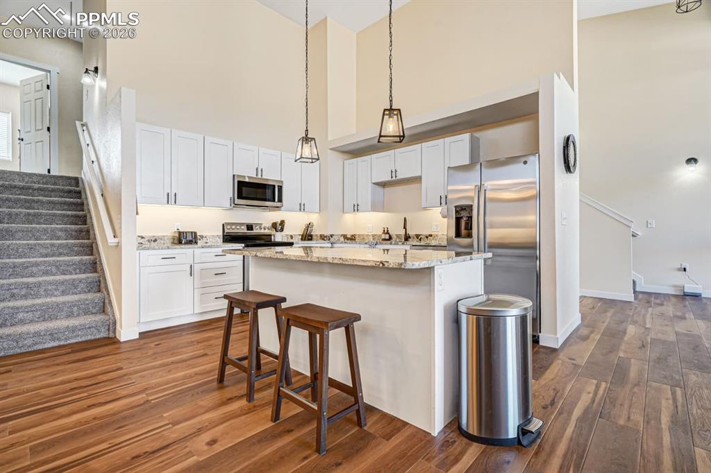 10108 Rolling Ridge Road Colorado Springs, CO 80925 - Photo 5 of 32 a kitchen with white cabinets and chair