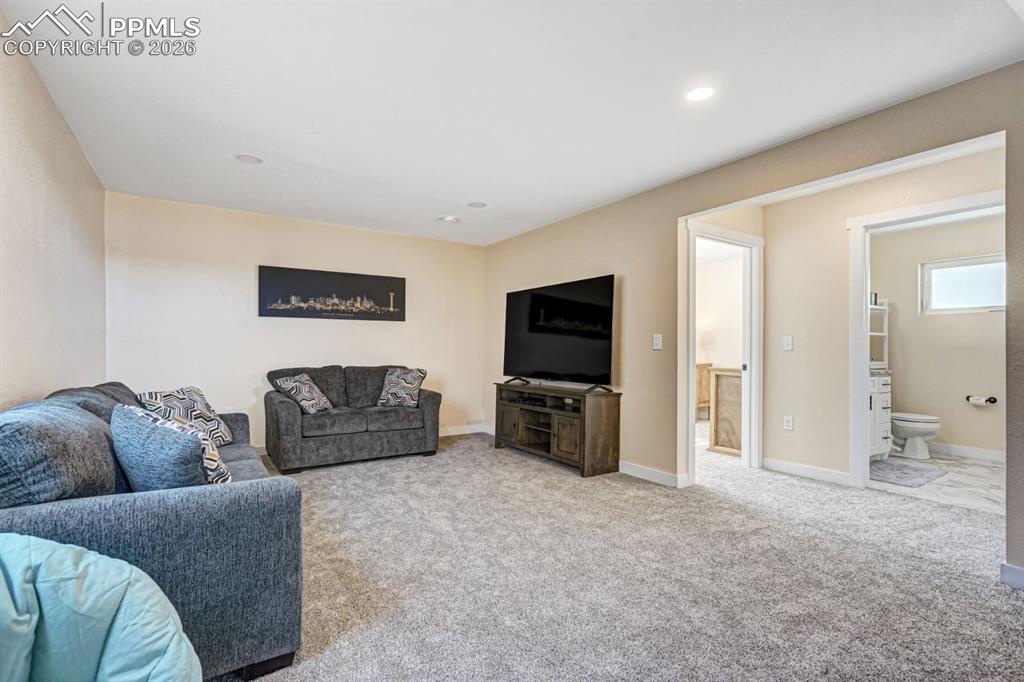 10108 Rolling Ridge Road Colorado Springs, CO 80925 - Photo 8 of 32 a living room with furniture and a flat screen tv