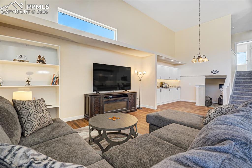 10108 Rolling Ridge Road Colorado Springs, CO 80925 - Photo 10 of 32 a living room with furniture kitchen view and a flat screen tv