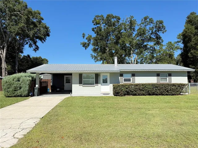 a view of a house with a yard and potted plants