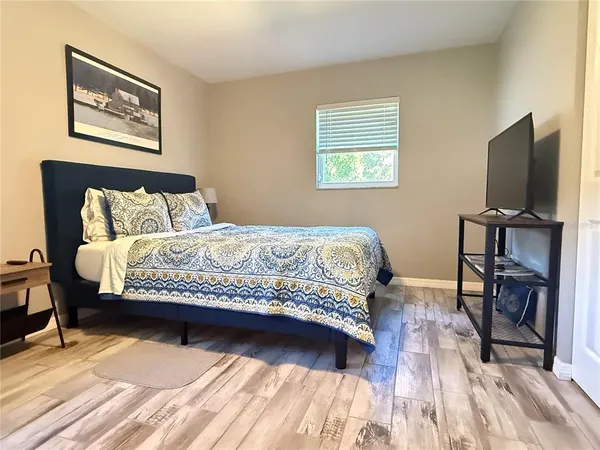 a bedroom with a bed and a flat screen tv