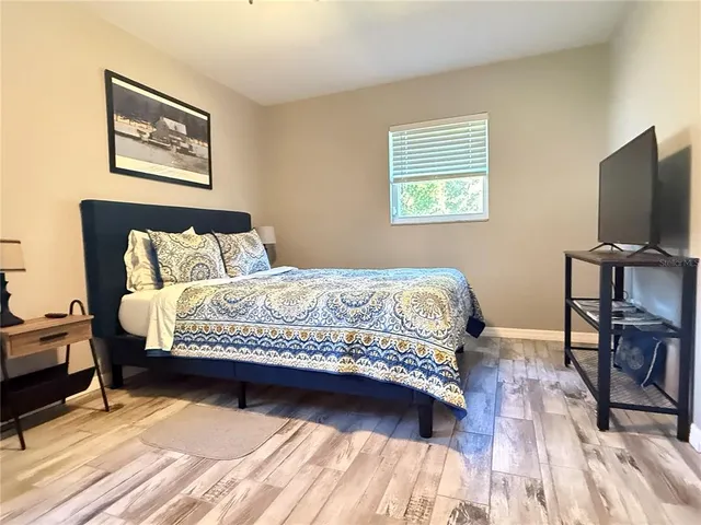 a bedroom with a bed and a flat screen tv
