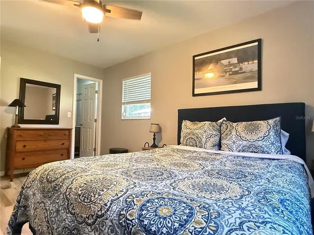 a bedroom with a bed and a ceiling fan