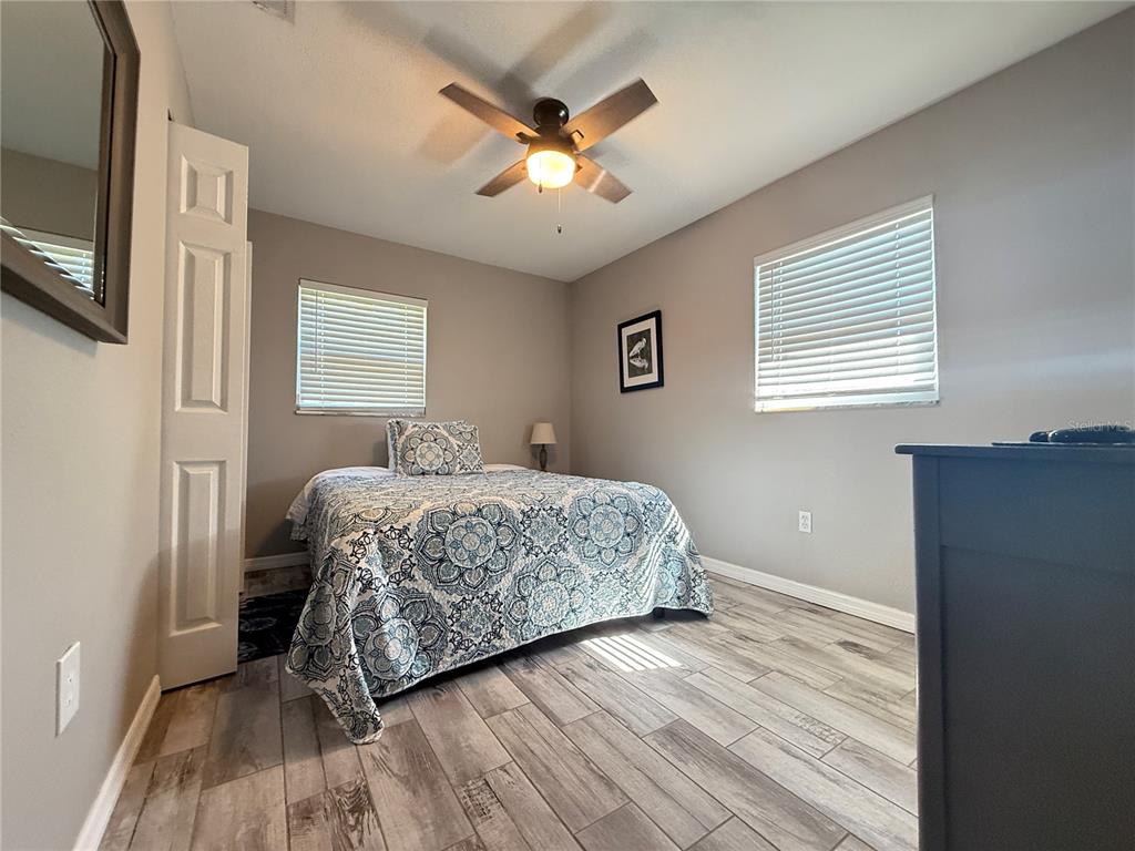 6809 Northwest 60th Street Ocala, FL 34482 - Photo 17 of 46 a bedroom with a bed and a ceiling fan