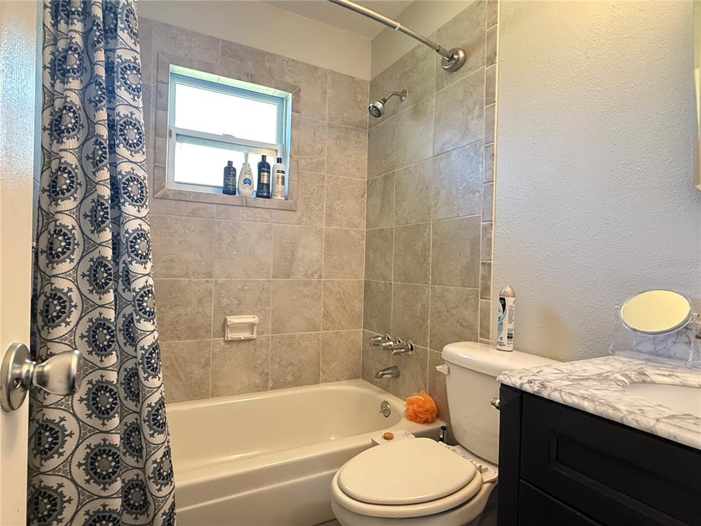 6809 Northwest 60th Street Ocala, FL 34482 - Photo 20 of 46 a bathroom with a granite countertop sink toilet a mirror and a bathtub