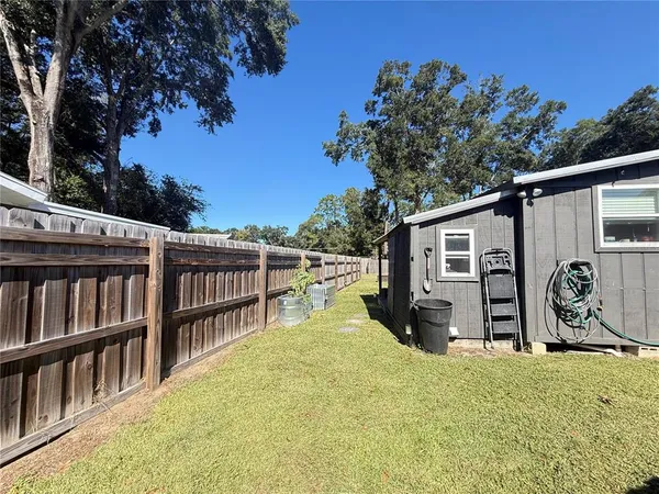 a view of a house with backyard and sitting area