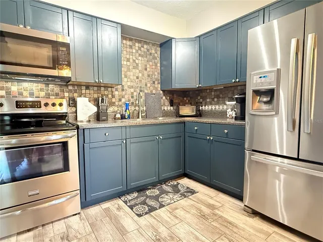 a kitchen with a sink stove and refrigerator