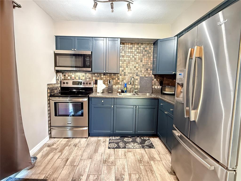 6809 Northwest 60th Street Ocala, FL 34482 - Photo 8 of 46 a kitchen with a sink stove and refrigerator