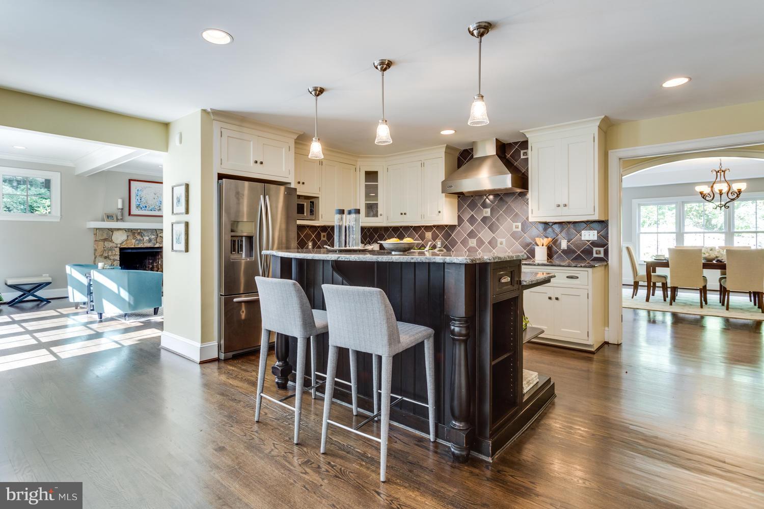 1700 Crescent Lane McLean, VA 22201 - Photo 9 of 30 a kitchen with stainless steel appliances a dining table chairs stove and white cabinets