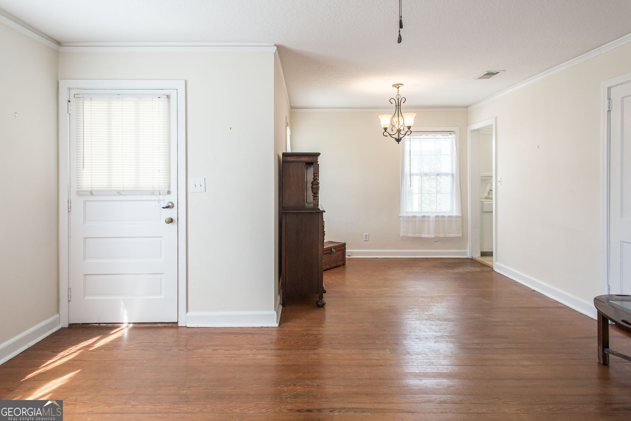 1009 Euclid Avenue Waycross, GA 31501 - Photo 6 of 35 an empty room with wooden floor chandelier and windows