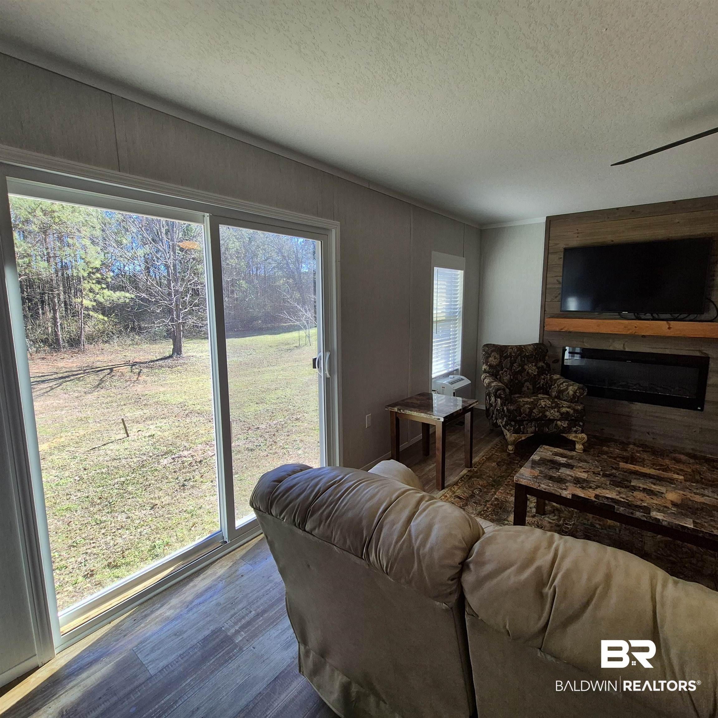 8867 Old Stage Road Repton, AL 36475 - Photo 5 of 37 Living room featuring a large fireplace, a textured ceiling, and wood finished floors