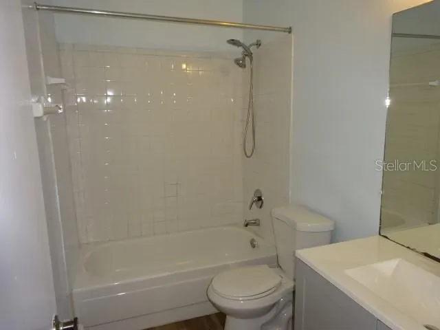 a white toilet sitting next to a bath tub