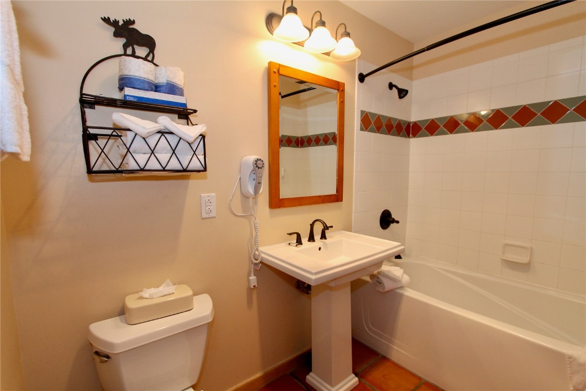 172 Copper Circle, Unit 301 Copper Mountain, CO 80443 - Photo 17 of 23 a bathroom with a sink a mirror a toilet and shower