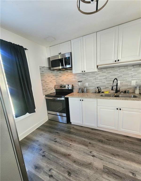 1279 Ridgecrest Lane Southeast Smyrna, GA 30080 - Photo 7 of 15 a kitchen with stainless steel appliances granite countertop a sink a stove a microwave and cabinets