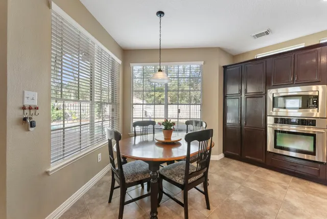 a dining room with furniture a chandelier and window