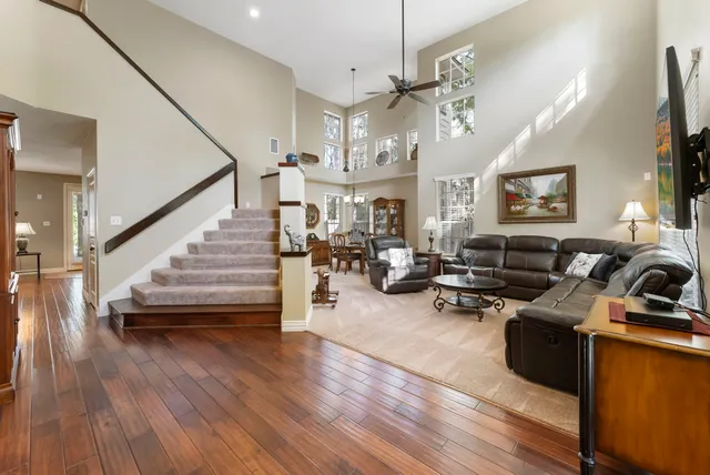 a living room with furniture kitchen view and a wooden floor