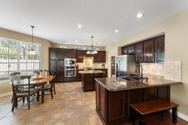 a kitchen with a refrigerator and a stove top oven