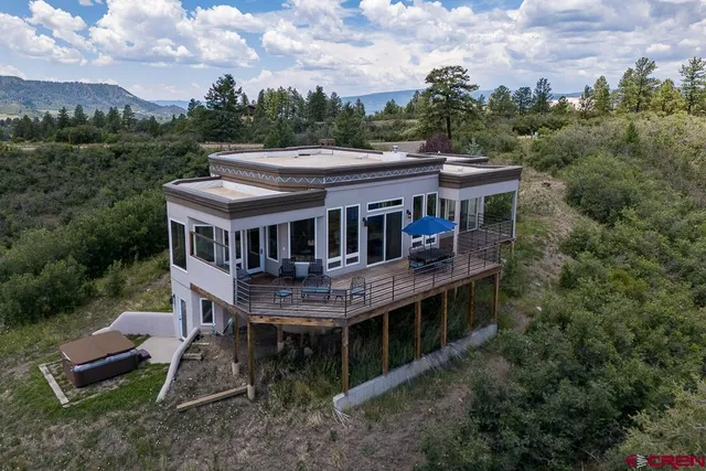 an aerial view of house with outdoor space and trees all around