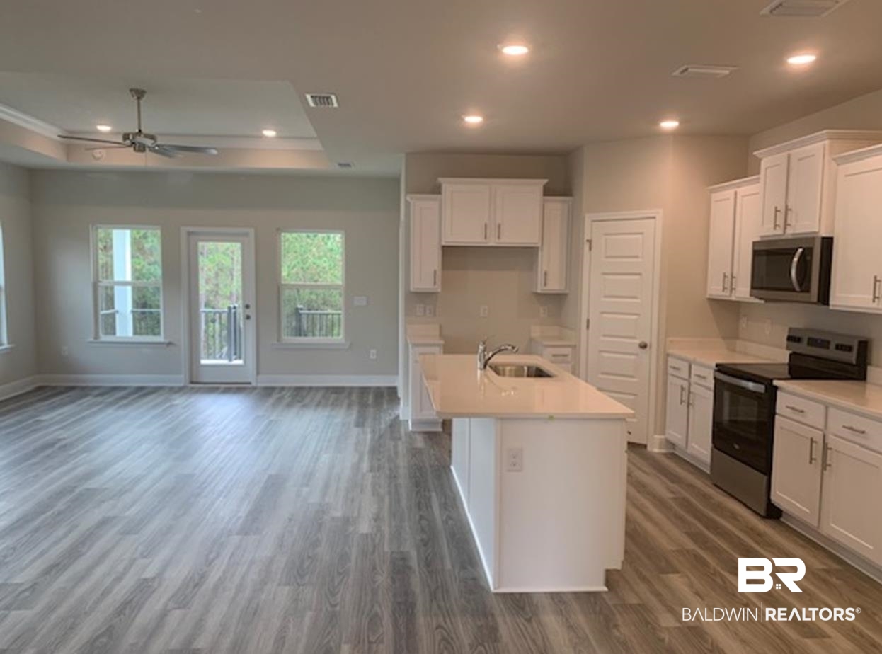 12904 Grand Rpds Road Fairhope, AL 36532 - Photo 29 of 34 Kitchen with a center island with sink, white cabinetry, appliances with stainless steel finishes, dark hardwood / wood-style flooring, and sink