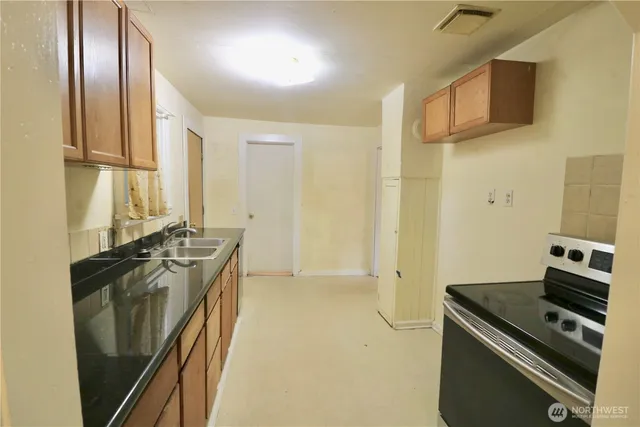 a kitchen with stainless steel appliances granite countertop a refrigerator and a stove