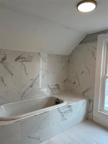 a spacious bathroom with a bathtub and shower