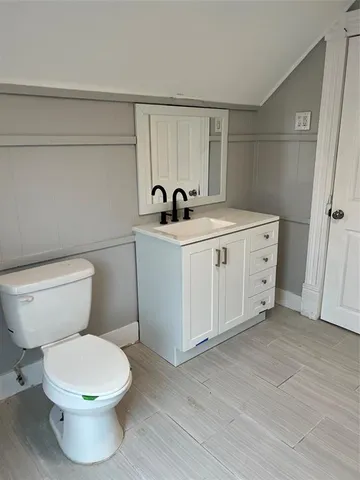 a view of bathroom with a toilet sink and mirror
