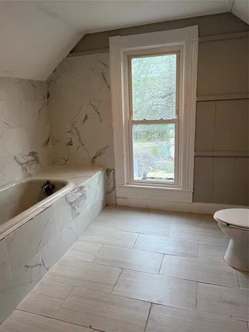 a view of a bathroom with a bathtub and window