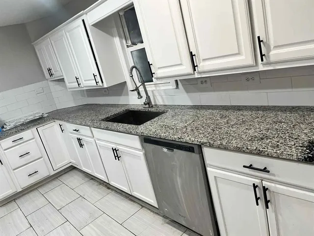 a kitchen with granite countertop white cabinets and white appliances