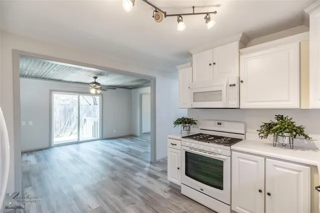 a kitchen with granite countertop a sink stainless steel appliances and cabinets