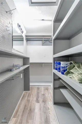 a view of walk in closet with clothes and shoes