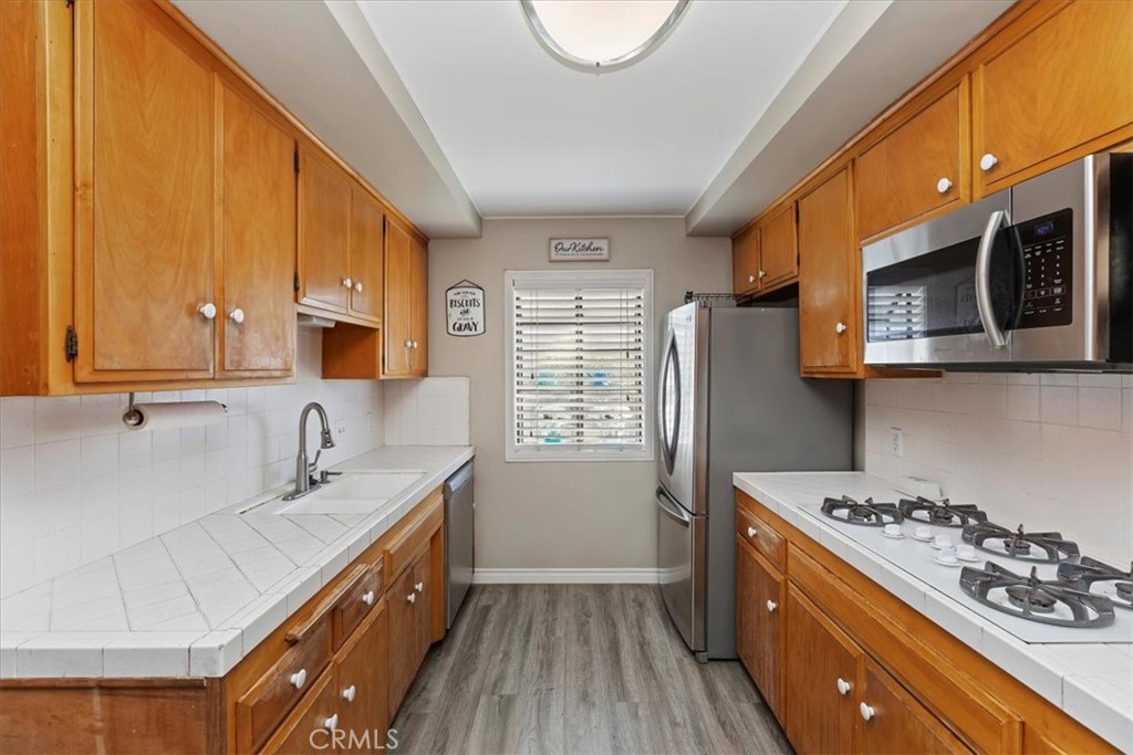 1441 Fifth Street Norco, CA 92860 - Photo 18 of 72 a kitchen with stainless steel appliances a stove a sink a refrigerator wooden floor and cabinets