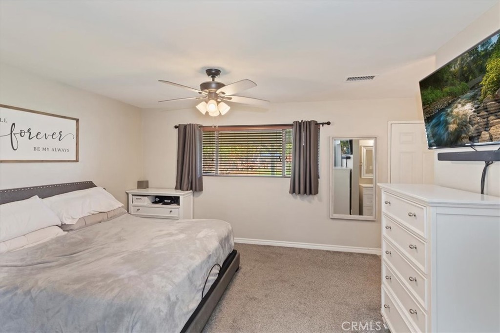 1441 Fifth Street Norco, CA 92860 - Photo 27 of 72 a bedroom with a bed a mirror and a flat screen tv