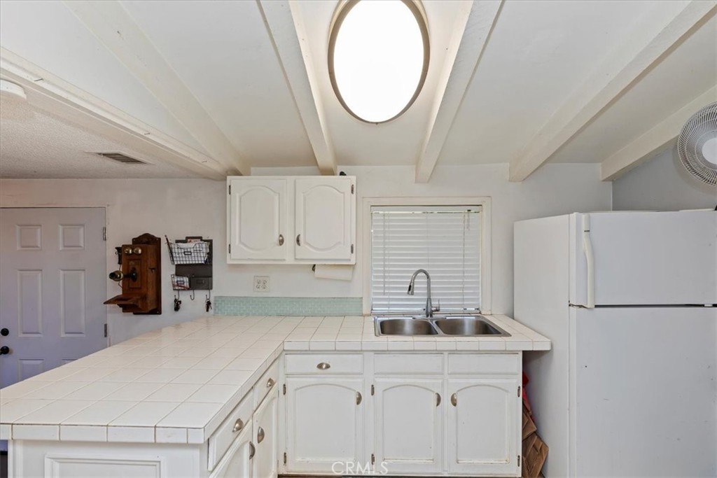 1441 Fifth Street Norco, CA 92860 - Photo 36 of 72 a kitchen with a sink a refrigerator and cabinets
