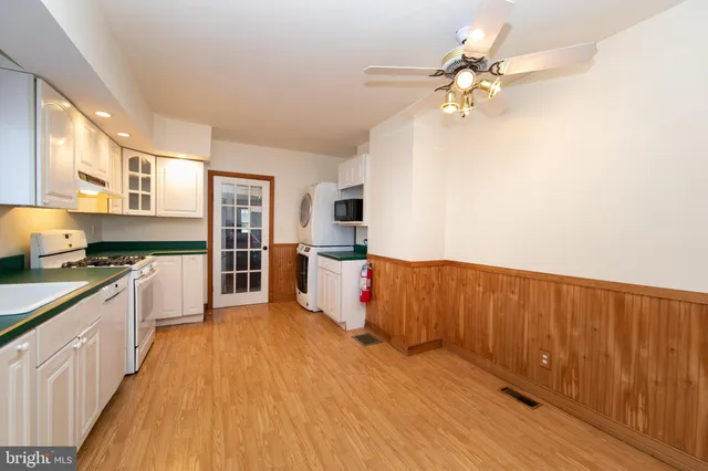 a large kitchen with cabinets wooden floor and stainless steel appliances