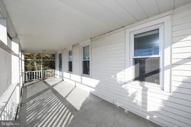 a balcony with white floor and wooden floor