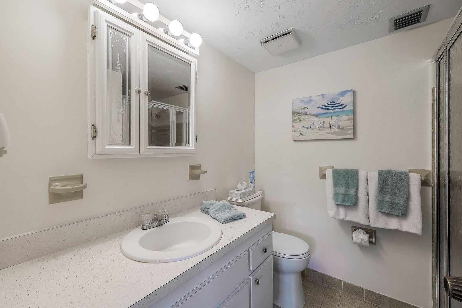 780 San Marco Road, Unit 104 Marco Island, FL 34145 - Photo 13 of 25 a bathroom with a granite countertop sink toilet and mirror