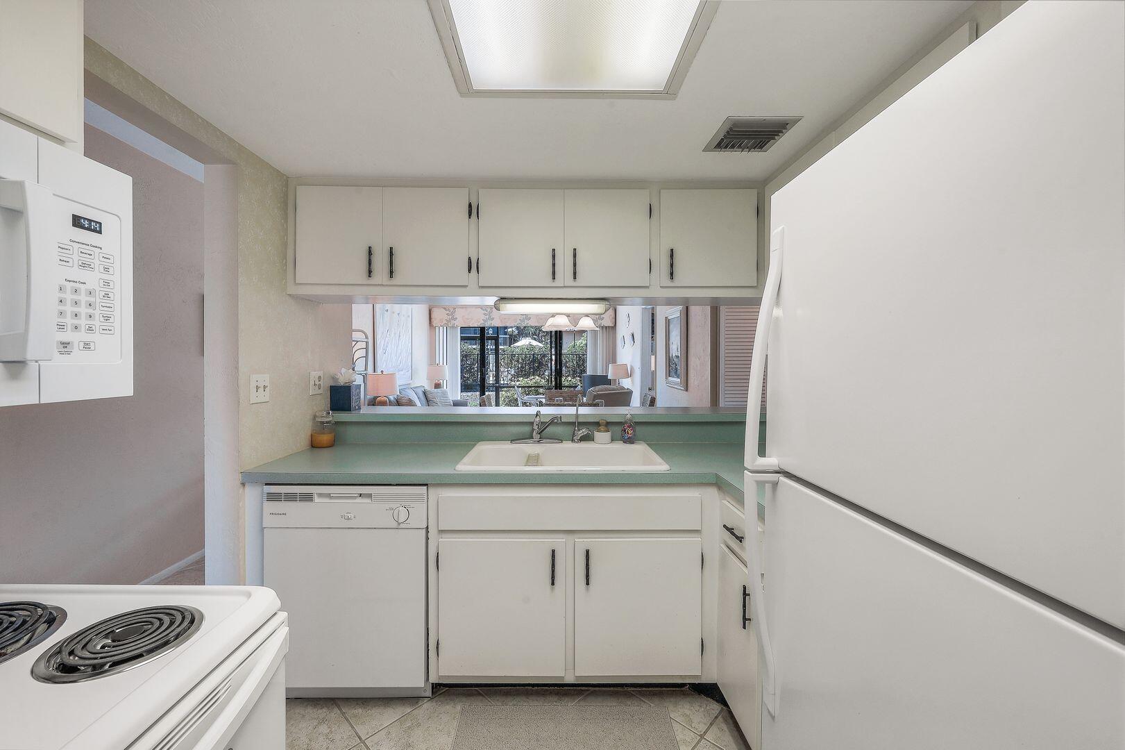 780 San Marco Road, Unit 104 Marco Island, FL 34145 - Photo 10 of 25 a kitchen with white cabinets and sink