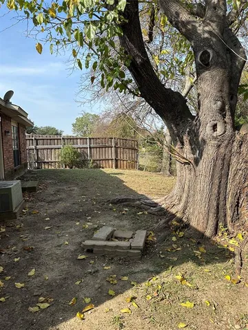 a view of a yard with wooden fence