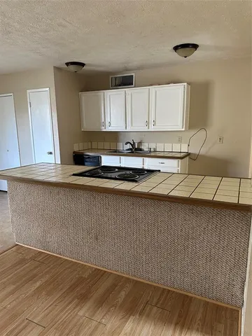 a kitchen with granite countertop a sink a stove and cabinets