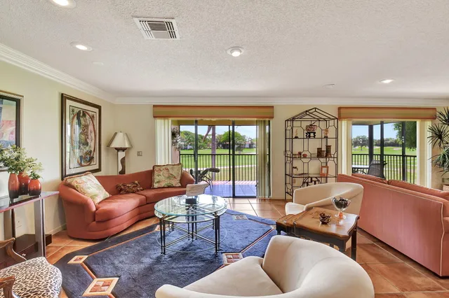 a living room with furniture a wooden floor and next to a window